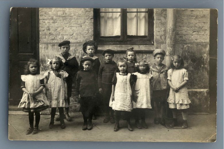 Børn samlet i baggård omkring 1900. 